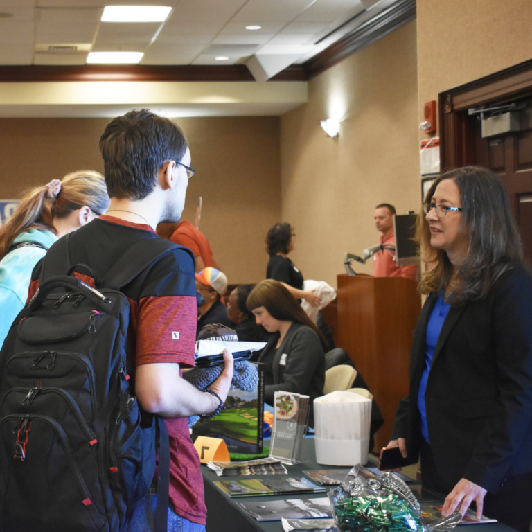 Image shows two students speaking with an employer at the Job Fair.